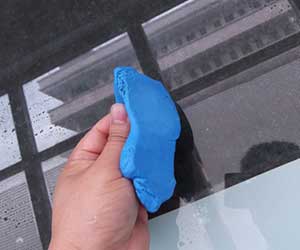 A technician is conducting a cleaning test using automotive cleaning mud.