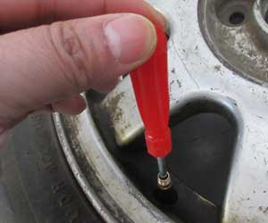 QC staff checking the valve fit of the emergency tyre puncture repair kit.