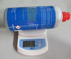 Digital weighing of the emergency tyre sealant bottle to verify fill quantity and MSDS specifications.