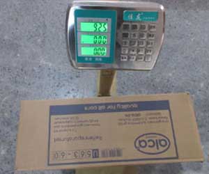 The Emergency Tire Repair Kit Shipping Carton is being weighed on a digital scale, displaying the gross weight for accurate logistics and quality control.