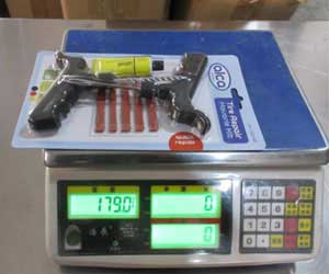 The Professional Tire Repair Kit is shown being weighed on a digital scale, displaying its precise weight for quality assurance and packaging verification.